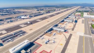 Overhead aerial view of Los Angeles International Airport LAX with runways, taxiways, and aircraft parked at gates during daytime with clear visibility of the tarmac and terminal buildings