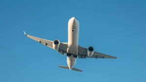 Modern commercial Boeing 767 aircraft in flight against clear blue sky, photographed from below showing the fuselage and wings in natural daylight, professional aviation photography