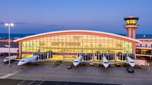 Halifax Stanfield International Airport terminal building exterior with modern architecture, aircraft parked at gates, Atlantic coast visible, daytime lighting, professional aviation infrastructure