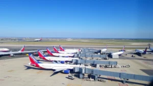 Aerial view of Dallas Love Field Airport with Southwest aircraft parked at gates, blue skies overhead, runway visible in background